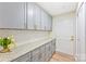 The pantry features gray cabinets with gold hardware and stone countertops at 103 Colonel Richard Rankin Dr, Stanley, NC 28164