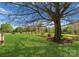 Beautifully landscaped backyard with lush green lawn and mature shade tree at 1052 Perth Rd, Troutman, NC 28166