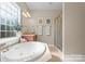 Bright bathroom featuring a soaking tub, glass-enclosed shower, and dual sinks at 1052 Perth Rd, Troutman, NC 28166