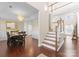 Dining room featuring wood floors, elegant chandelier, staircase, and decorative wainscoting at 1052 Perth Rd, Troutman, NC 28166
