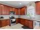A modern kitchen with stainless steel appliances, tile backsplash and wooden cabinets at 1052 Perth Rd, Troutman, NC 28166