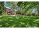 Large, beautiful backyard with a sprawling lawn, mature trees, and a view of the home's deck at 10609 Oak Pond Cir, Charlotte, NC 28277