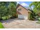 Brick home exterior featuring a two-car garage and lush landscaping, plus a long concrete driveway at 10609 Oak Pond Cir, Charlotte, NC 28277