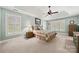 Comfortable bedroom with plush carpet, tray ceiling, ceiling fan, and plantation shutters at 10609 Oak Pond Cir, Charlotte, NC 28277