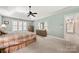 Bright bedroom featuring plush carpet, ceiling fan, plantation shutters, and ensuite access at 10609 Oak Pond Cir, Charlotte, NC 28277