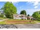 Inviting single-story home featuring mature trees, a cozy porch, and landscaped front yard at 1068 14Th Nw Ave, Hickory, NC 28601