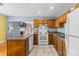 Open kitchen concept with wooden cabinetry, essential appliances, and tiled floors at 1068 14Th Nw Ave, Hickory, NC 28601