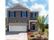 Charming two-story home with gray siding, stone accents, a two-car garage, and a well-manicured front yard at 121 Falling Up Ln, Salisbury, NC 28147
