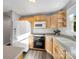 Functional kitchen with wooden cabinets, white appliances, gray countertops, and durable vinyl flooring at 1277 Rainbow Cir, Catawba, SC 29704