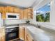 Well-lit kitchen featuring wooden cabinets, modern appliances, and a large window with a scenic view at 1277 Rainbow Cir, Catawba, SC 29704