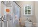 This bathroom features a toilet, window and a shower with an abstract curtain at 1317 Waynewood Dr, Waxhaw, NC 28173