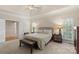 Comfortable main bedroom with bench, bedside tables, natural light, and tray ceiling at 1317 Waynewood Dr, Waxhaw, NC 28173