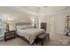 Cozy main bedroom with a seating bench, tray ceiling, and two bedside tables at 1317 Waynewood Dr, Waxhaw, NC 28173