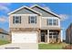 Two-story home featuring stone accents, gray siding, a two-car garage, and well-maintained landscaping at 133 Falling Up Ln, Salisbury, NC 28147