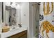Bathroom featuring decorative shower curtain, mirror and sink with wood cabinet at 13843 Poppleton Ct, Charlotte, NC 28273