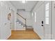 Bright foyer with hardwood floors, staircase with carpet runner, and paneled walls at 13843 Poppleton Ct, Charlotte, NC 28273