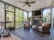 Inviting back porch featuring a stone fireplace, ceiling fan and comfortable seating at 143 Robinson Ridge Dr, Mooresville, NC 28117