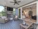 Inviting back porch featuring a stone fireplace, ceiling fan and comfortable seating at 143 Robinson Ridge Dr, Mooresville, NC 28117