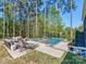 Backyard oasis featuring an in-ground pool, hot tub, lounge chairs and wooded views at 143 Robinson Ridge Dr, Mooresville, NC 28117