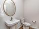 Half bath with pedestal sink, modern fixtures, a round mirror, and ceramic toilet at 143 Robinson Ridge Dr, Mooresville, NC 28117