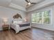 Bright bedroom with large windows, hardwood floors, ceiling fan, and tray ceilings at 143 Robinson Ridge Dr, Mooresville, NC 28117