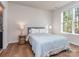 Bedroom with hardwood floors, natural light, and a comfortable bed with lamps on each side at 143 Robinson Ridge Dr, Mooresville, NC 28117