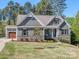 Attractive home with stone accents, an attached garage, a driveway, and manicured landscaping at 143 Robinson Ridge Dr, Mooresville, NC 28117