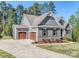 Gray home with an attached two car garage, driveway, stone accents and manicured landscaping at 143 Robinson Ridge Dr, Mooresville, NC 28117