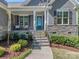 Inviting front porch with stone steps, teal door, black shutters and manicured landscaping at 143 Robinson Ridge Dr, Mooresville, NC 28117