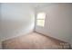 This bedroom has neutral carpet, a window, and is freshly painted at 14608 Arlandes Dr, Charlotte, NC 28278