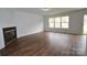 Inviting living room with wood-look floors, a fireplace, and large windows for ample light at 14608 Arlandes Dr, Charlotte, NC 28278
