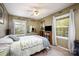 Inviting bedroom boasts natural light, ceiling fan, and a comfortable bed with decorative quilt at 147 Spring Shore Rd, Statesville, NC 28677