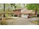 Two-story brick home with attached garage and carport has a well manicured lawn with mature trees at 147 Spring Shore Rd, Statesville, NC 28677