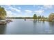 Scenic lake view with multiple docks and calm waters surrounded by lush greenery under a partly cloudy sky at 147 Spring Shore Rd, Statesville, NC 28677