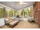 Relaxing screened porch with comfortable seating, ceiling fan, and views of the surrounding trees at 147 Spring Shore Rd, Statesville, NC 28677