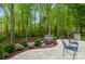Serene backyard featuring a stone patio, lush landscaping, and tranquil water fountain at 1813 Wedowee Ct, Rock Hill, SC 29732