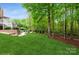 Expansive backyard with lush lawn, mature trees, and a charming patio area at 1813 Wedowee Ct, Rock Hill, SC 29732