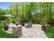 Beautiful brick patio with an outdoor fire pit, comfortable seating, and a lush, wooded backdrop creating a private retreat at 1813 Wedowee Ct, Rock Hill, SC 29732