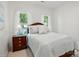Well-lit bedroom featuring a wood nightstand and plush bedding at 19416 Fridley Ln, Cornelius, NC 28031