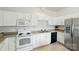Functional kitchen featuring white cabinets, essential appliances, and ample countertop space at 19416 Fridley Ln, Cornelius, NC 28031