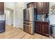 Modern kitchen showcasing stainless steel refrigerator, dark cabinets, and a wood laminate floor at 2077 Taney Way, Fort Mill, SC 29707