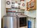 Well-organized laundry room featuring front-load washer and dryer, upper cabinets and decorative shelving at 2077 Taney Way, Fort Mill, SC 29707