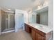 Large primary bath with double sink vanity, tiled floor, and glass shower at 2163 Woodstream Rd, Harrisburg, NC 28075