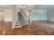 Bright foyer features hardwood floors, staircase with carpet runner and neutral paint at 2163 Woodstream Rd, Harrisburg, NC 28075