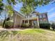 Charming brick two-story home featuring a welcoming front porch and beautifully landscaped front yard at 2163 Woodstream Rd, Harrisburg, NC 28075