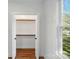Bedroom closet with painted shelving, hanging rods and hardwood floors at 224 Adrian St, Mount Holly, NC 28120