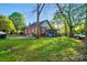 Spacious backyard features lush lawn, mature trees, and brick exterior with a screened-in porch, offering a serene outdoor space at 247 W Park Ave, Charlotte, NC 28203