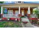 Charming front porch with classic brick columns, white railings, and decorative plants, offering a welcoming entrance at 247 W Park Ave, Charlotte, NC 28203