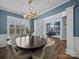 Bright dining room featuring a modern chandelier, hardwood floors and multiple windows at 253 Memory Ln, Rock Hill, SC 29732