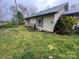Shows a dilapidated house with peeling paint, overgrown vegetation and in need of renovation at 2702 W Stage Coach Trl, Shelby, NC 28150